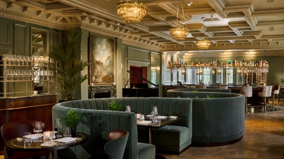 Elegant restaurant with curved booths and a bar.