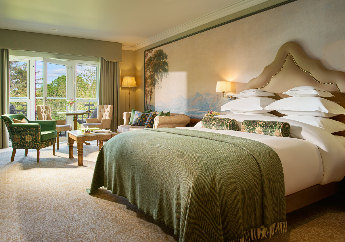 A king size bed with a balcony in the Deluxe King Balcony Guest Room.
