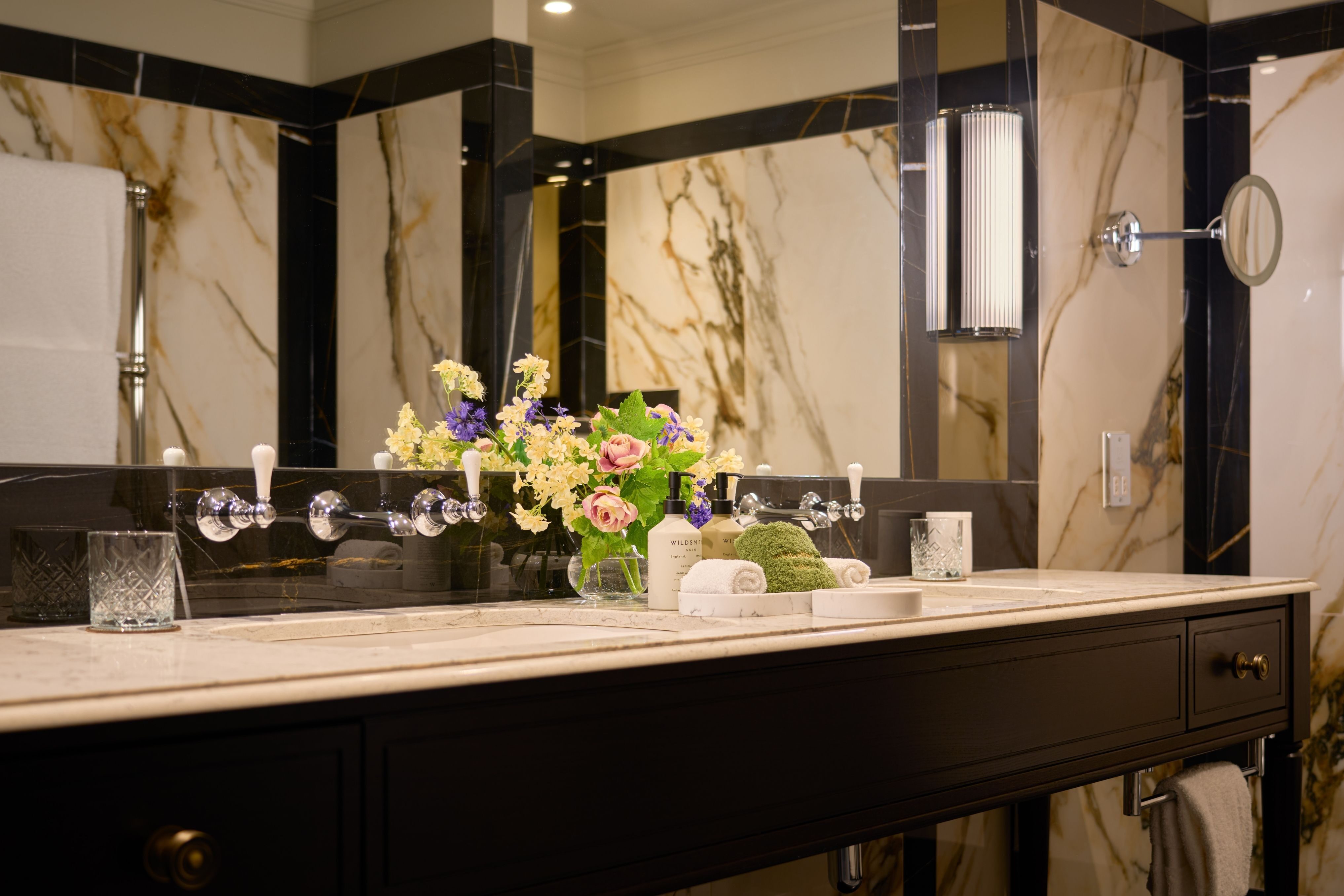 Elegant and	Modern suite bathroom with warm lighting, marble countertops, double vanity and premium toiletries.