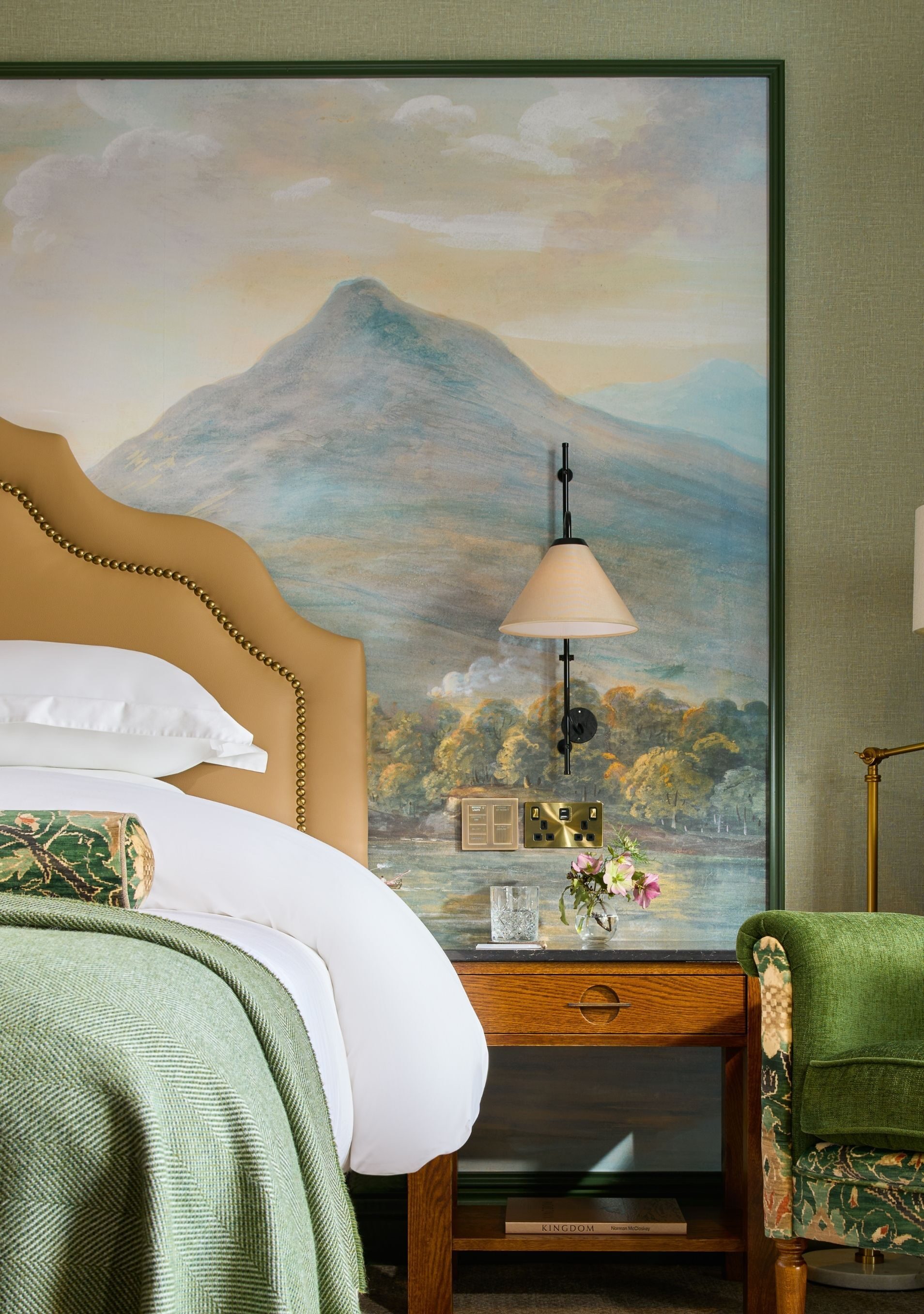 a beautiful mural behind the bedside table and king-size bed.