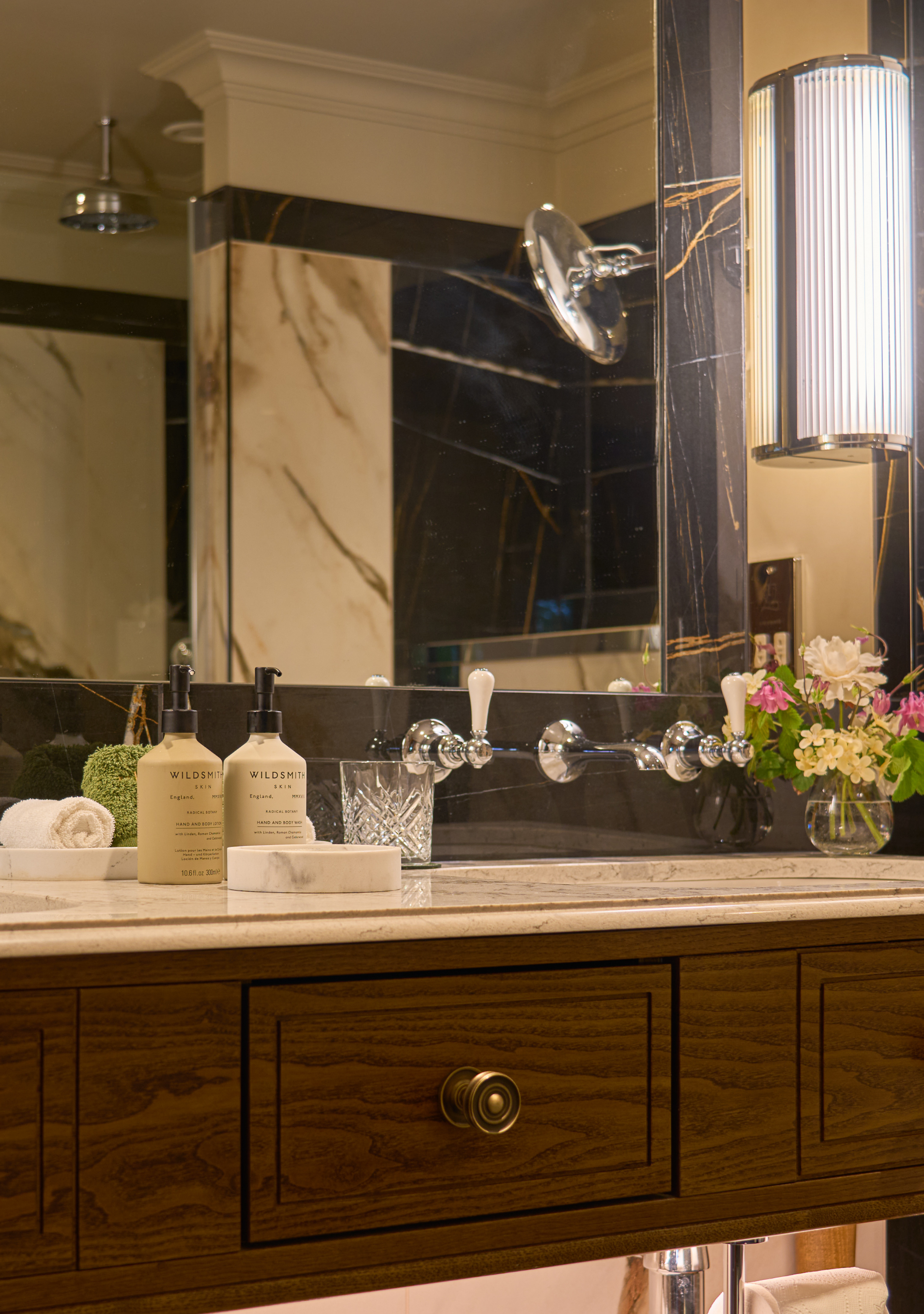 Premium toiletries (Wildsmith) on a marble countertop and a vanity in ensuite bathroom.