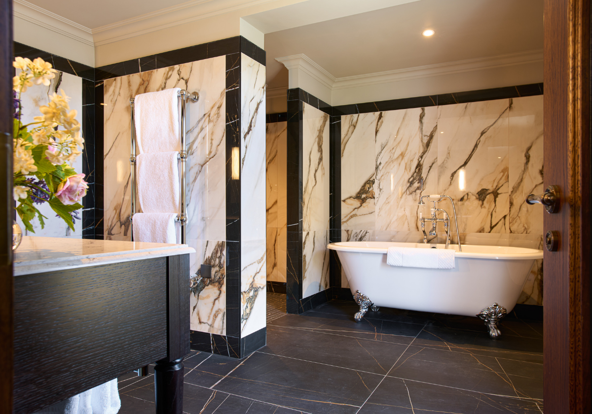 Spacious ensuite bathroom with double vanity, walk-in rainfall shower and claw foot bathtubs.