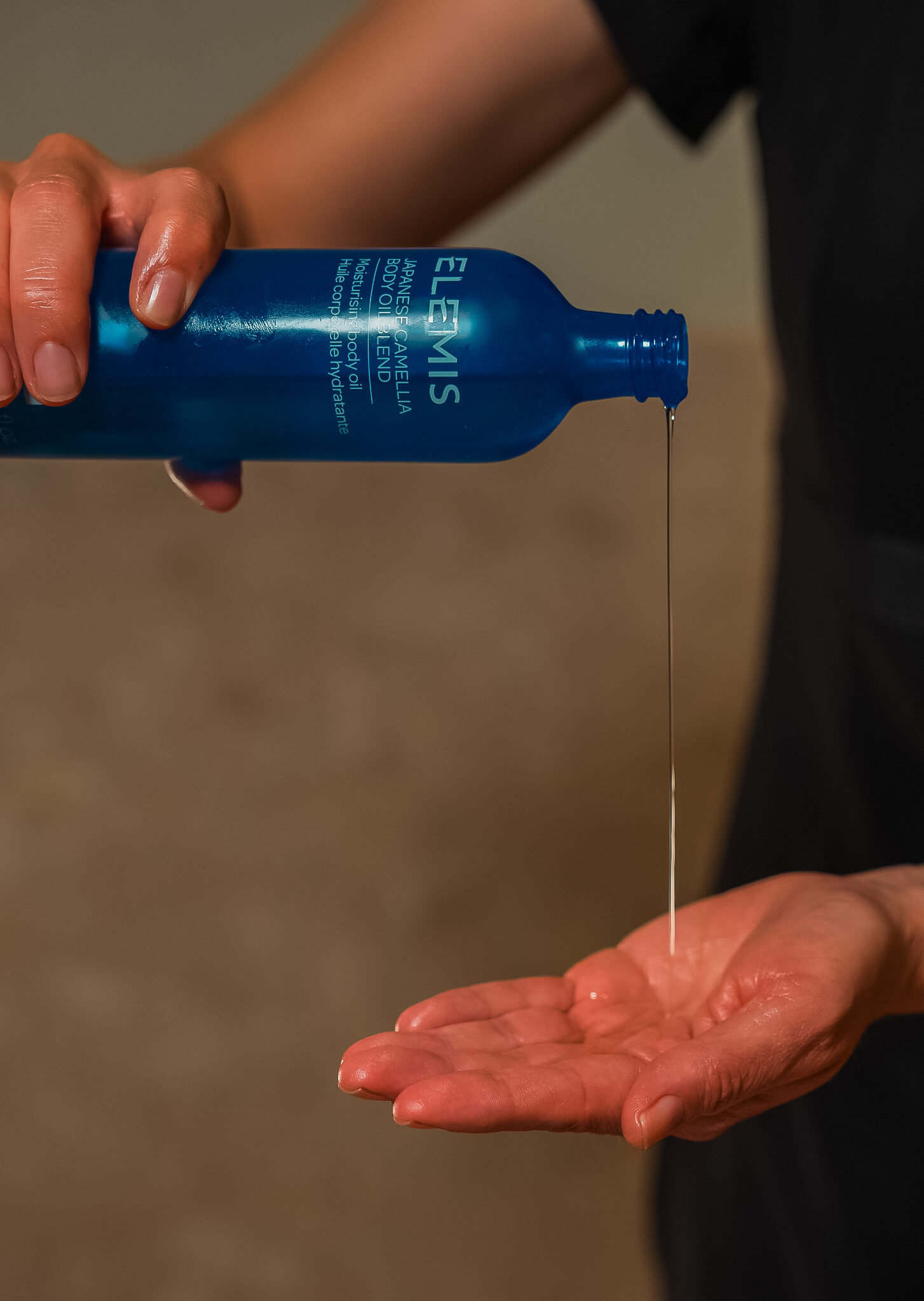 Masseuse seen using Elemis London products for wellness services/ spa treatment.