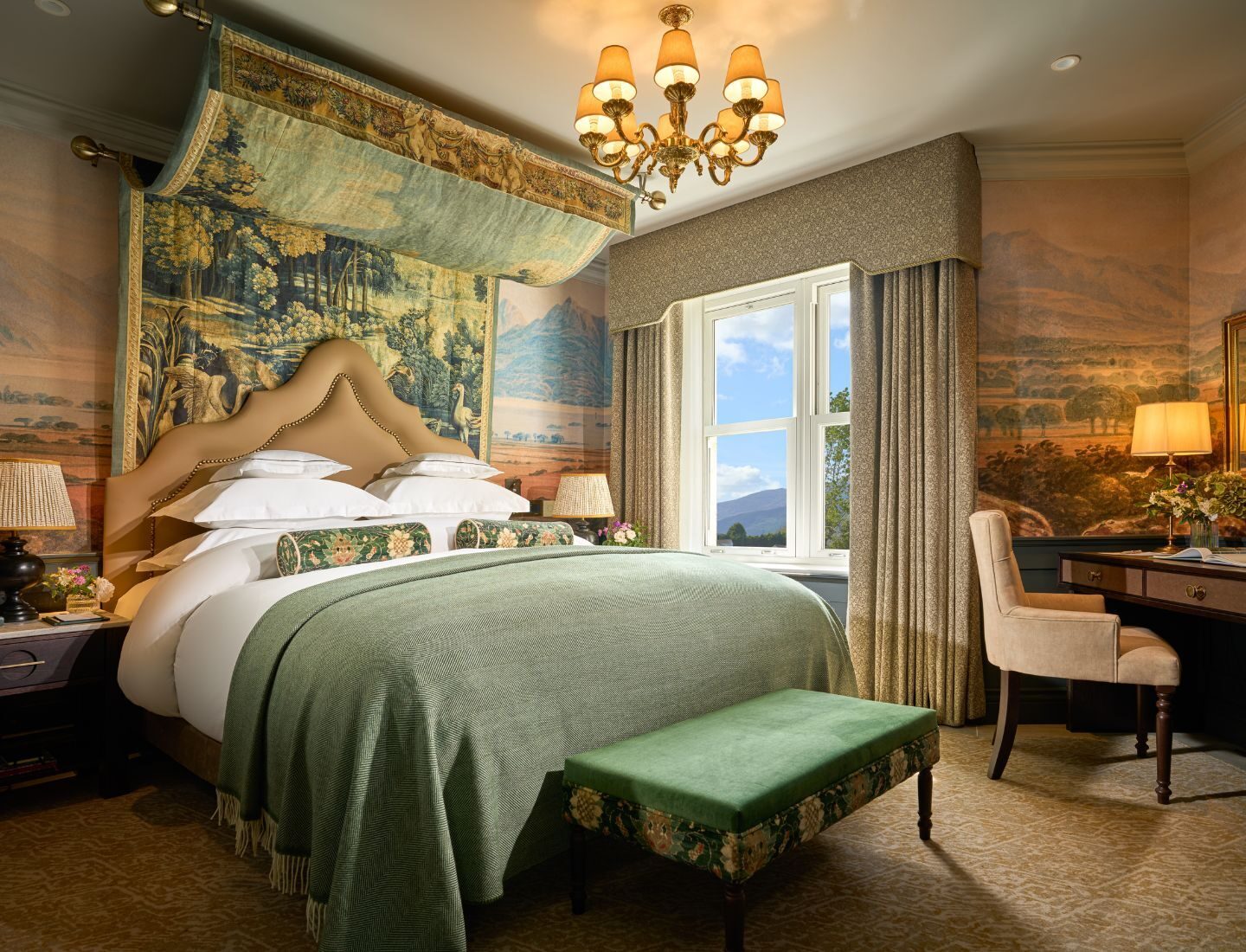 This is The Garden Suite- There is King Size Bed, Stack of comfortable white pillows, a writing table, chandelier and a big window.