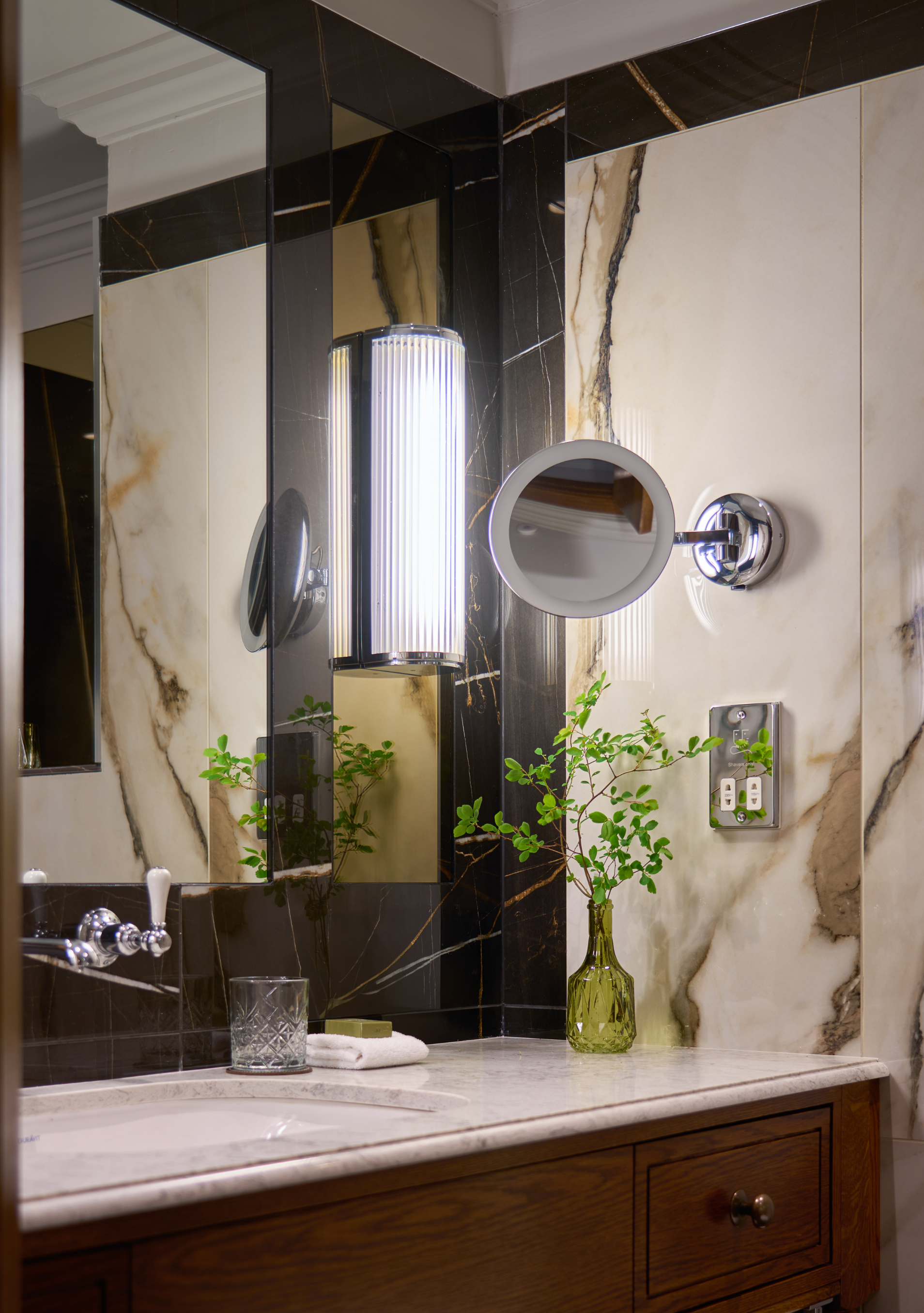 Modern Suite Bathroom Vanity Details- Warm Lighting, Marble Countertop, Big Mirror and Premium Toiletries.