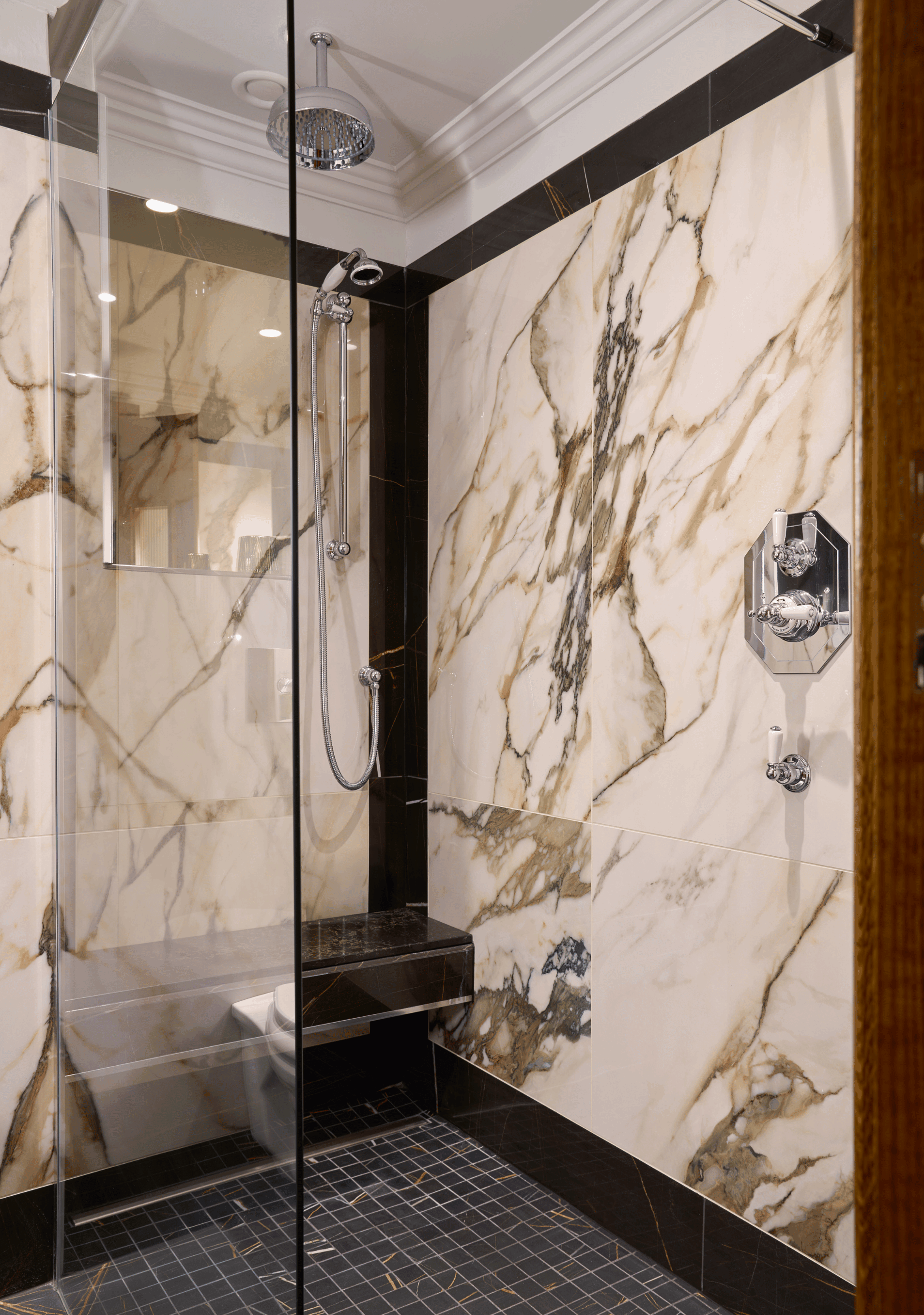 Elegant and	Modern suite bathroom with warm lighting, glass shower enclosure, head and hand showers.