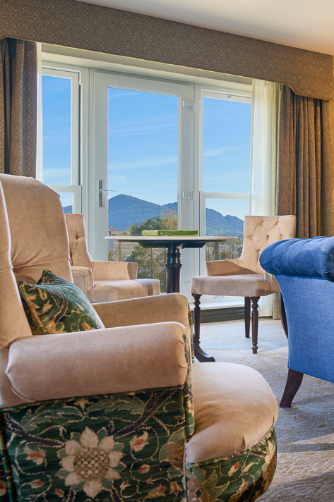 This is the Living room area with comfortable accent chairs with a garden view in The Garden Suite.