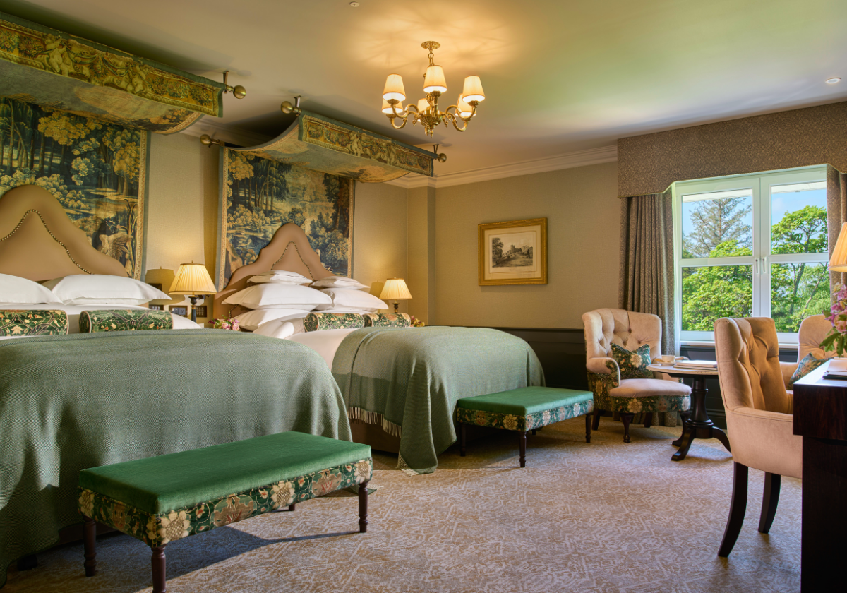 Two King-Size comfortable beds with accent chairs for reading or writing with a pleasant of Killarney in The Muckross Suite.