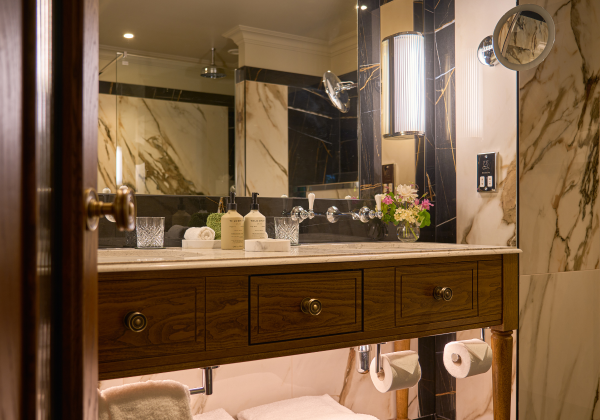 Elegant suite bathroom with warm lighting, double vanity, premium toiletries &  minimalist décor.