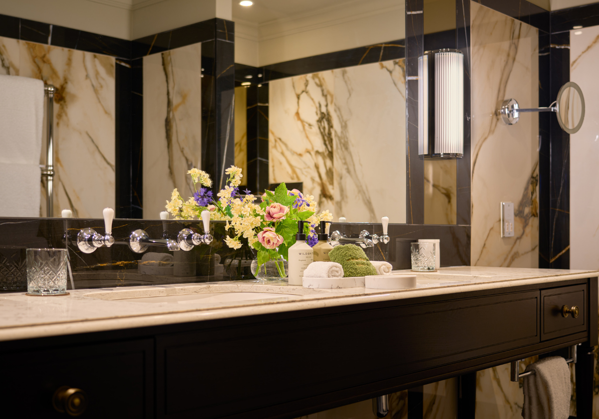 Luxurious suite bathroom with marble countertop, double vanity and premium toiletries.